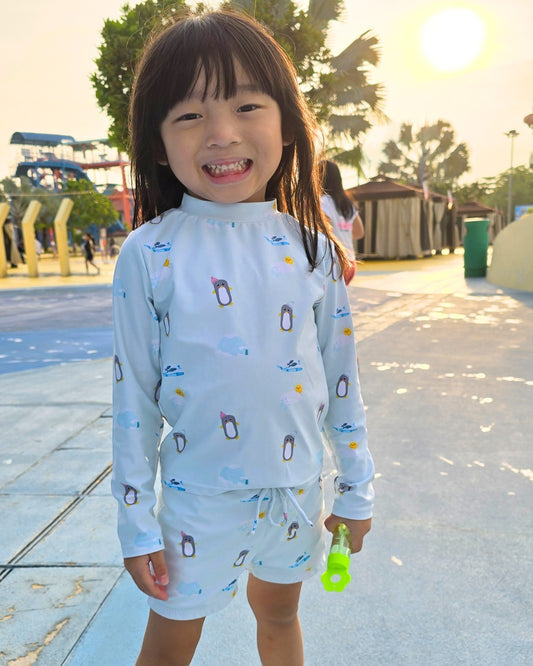 Lilbubsy mint penguin 3pc swimsuit set with UPF 50+ protection. Includes rash guard, shorts, and bucket hat.